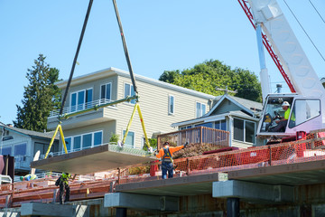 Crane lifting concrete panel for boardwalk