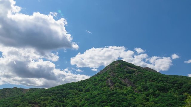 Sky with clouds over mountains, time lapse, / Blue sky with white clouds over green mountains, time lapse