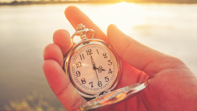 Close Up Hand Holding Pocket Watch At The Riverside In The Evening.