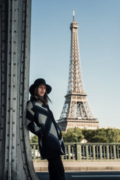 Portrait of young woman in front of Eiffel Tower, Paris, France