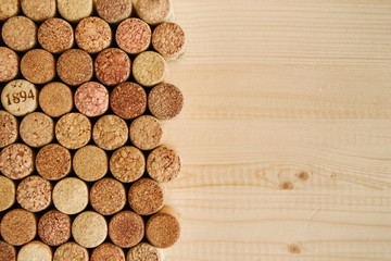 A lot of wine textured wine cork on the wooden background close up, top view.