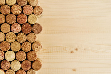 A lot of wine textured wine cork on the wooden background, top view.