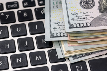 dollar banknotes above white keyboard. close up