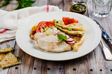 Turkey cutlets served with vegetables, pita bread with pesto and cream sauce. Copy space