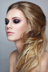 Naklejka premium Beautiful blonde girl with stylish messy hairdo and smoky eyes make-up
