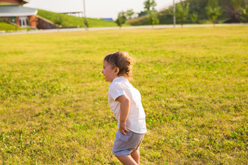 Summer, childhood and baby concept - little boy having fun in summer nature