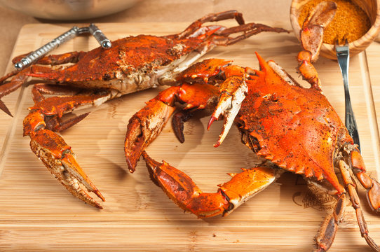 Pile Of Steamed And Seasoned Chesapeake Bay Blue Claw Crabs / On A Wood Cutting Board With A Steel Cracker And A Wood Bowl Of Spicy,seasoning On Brown Paper Table Covering