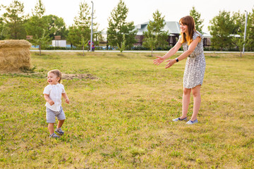 Fototapeta premium Cute cheerful child with mother play outdoors in park