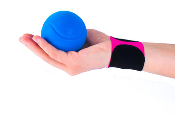 hand with kinesiology tape and stressball.  Physiotherapy and therapeutic tape for wrist pain, aches and tension. elastic therapeutic tape. adhesive tape and alternative medicine.