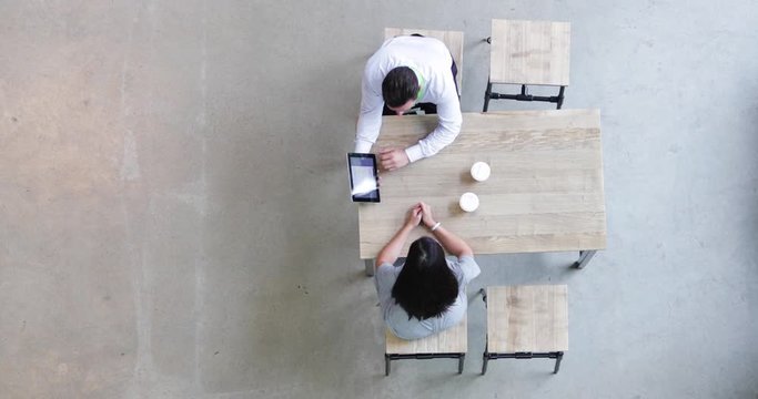 Overhead shot of a colleagues using a digital tablet in a business meeting