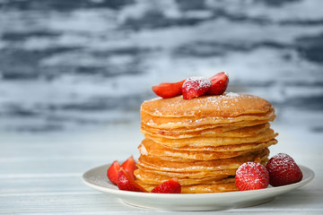 Plate with delicious pancakes on blurred background