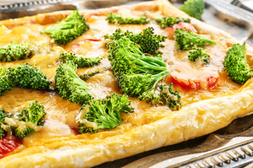 Traditional quiche with broccoli and cheese on tray, close up