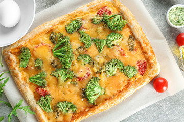 Traditional quiche with broccoli and cheese on table