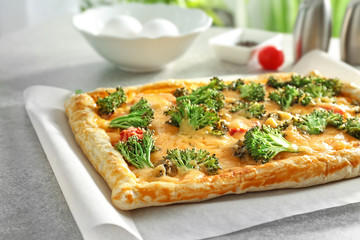 Traditional quiche with broccoli and cheese on table