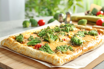 Traditional quiche with broccoli and cheese on wooden board