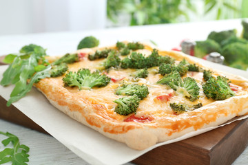 Traditional quiche with broccoli and cheese on board, close up