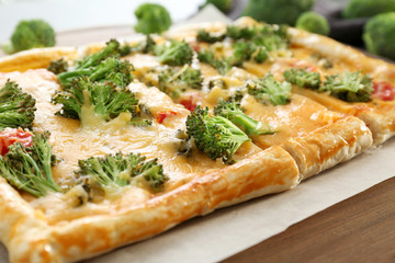 Traditional quiche with broccoli and cheese on board, close up