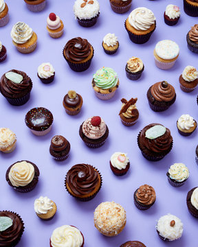 Gourmet Cupcakes in Grid Pattern on Purple Background