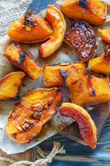 Slices of pumpkin roasted with honey on a parchment.