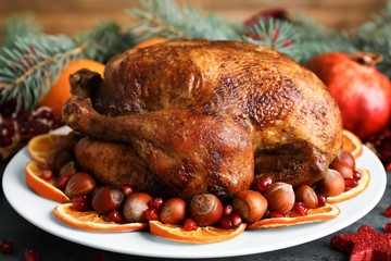 Plate with tasty whole roasted turkey on table