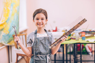 The girl is holding a tool for performing ebru technique