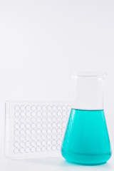  research, science and clinic background. 96 well micro plate and  laboratory beakers with colorful liquids and reagents.  
