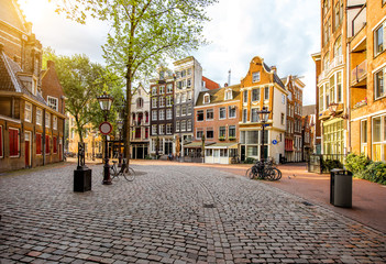Fototapeta premium Poranny widok na plac z pięknymi budynkami w pobliżu Starego Kościoła w Amsterdamie