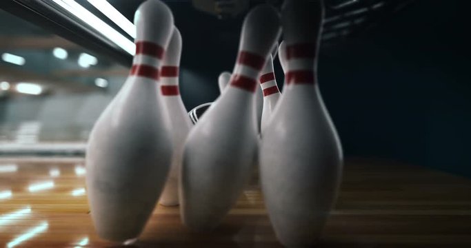 Bowling strike, bowling ball knocks down bowling pins in slow motion
