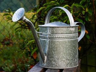 Metallgie&szlig;kanne auf einer Holzbank