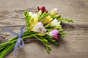 Colorful freesia flowers on wooden background - obrazy, fototapety, plakaty