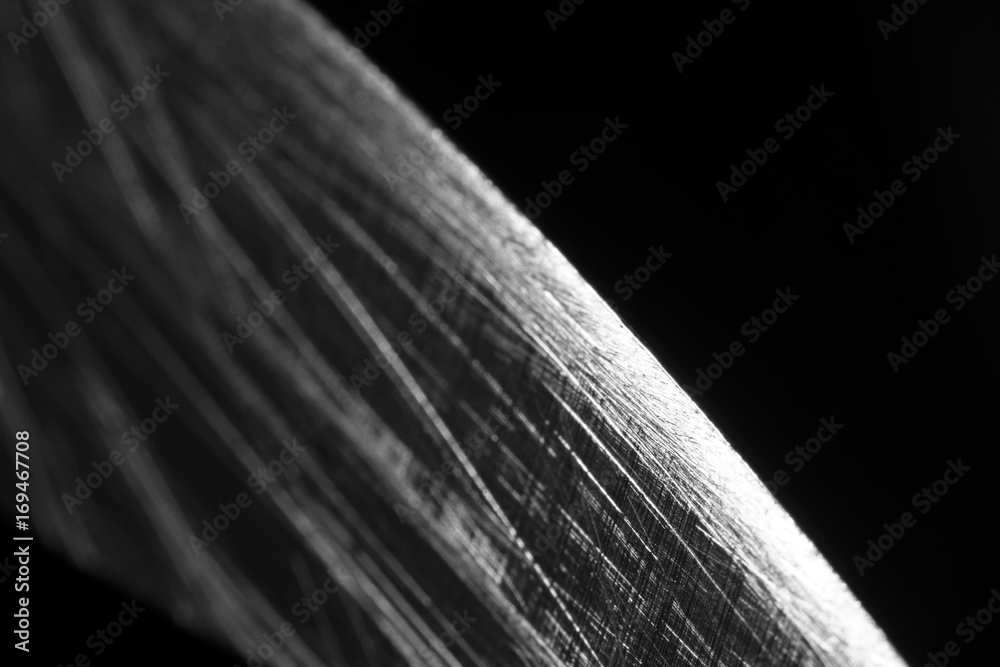 Wall mural Macro blade of a knife with scratches on a black background, soft focus