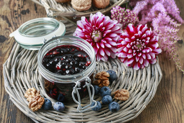 Jar of blueberry jam and dahlia flowers