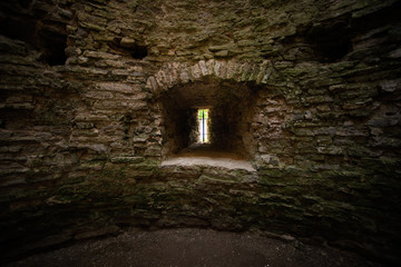 Fototapeta na wymiar Window loophole in the ancient medieval limestone tower