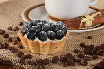 A cup of black vanilla coffee with berry cake