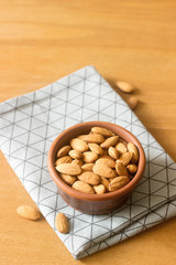 Almonds in a clay bowl on a wooden table