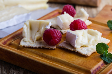 Brie cheese with fresh raspberries and crackers