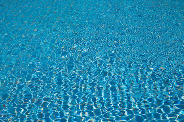 Blue pool water with sun reflections
