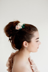 Portrait of beautiful girl with dark hair and light porcelain skin. Hair in a bun. Hair accessory handmade
