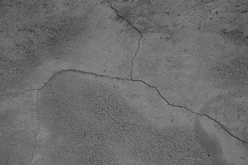 Cracked concrete wall covered with gray cement - background