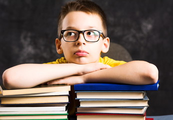 Boy taking a rest on top of books