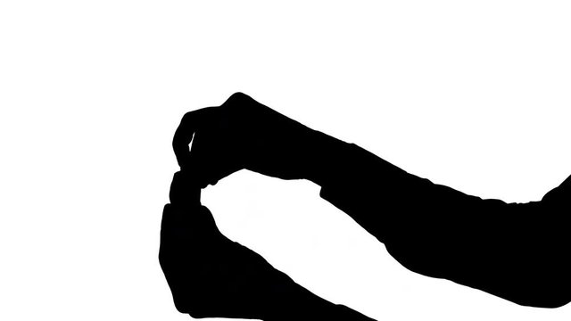 Moving male hands unwrapping a candy Moving black silhouette of male hands with one hand holding a wrapped candy and the other hand unwrapping the candy, against white background with background sound