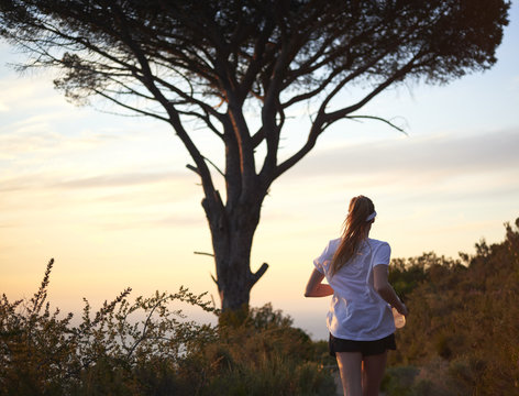 Healthy female with long hair trail running in a beautiful area