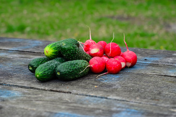 Radish and cucumbers on wooden table