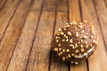 One chocolate cookie over brown wooden background
