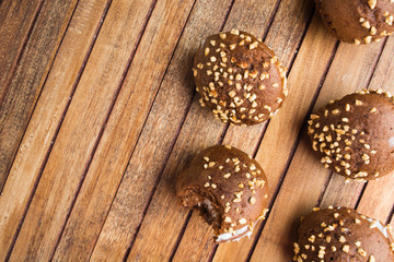 Group of chocolate cookies with cream and nuts over wooden table