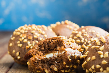 Chocolate cookies with whipped cream and nuts on blue background