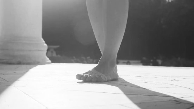 Bare feet of a woman dancing on a stone floor