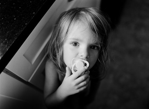 A little girl regresses with pacifier