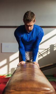 Male gymnast performing on pommel horse