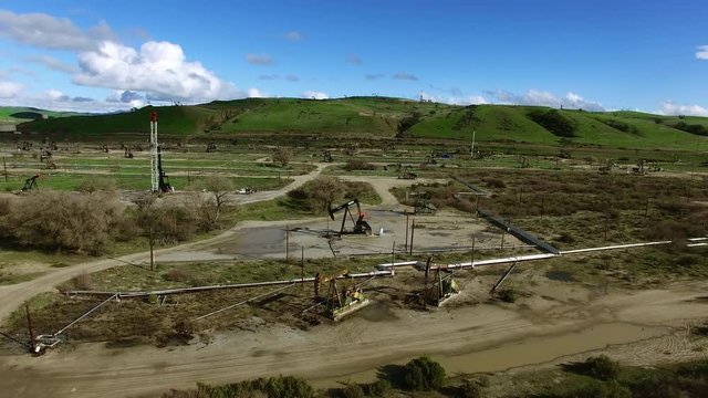 Deserted Area With Oil Pumping Machines In A Middle Of Green Field Shot From Above